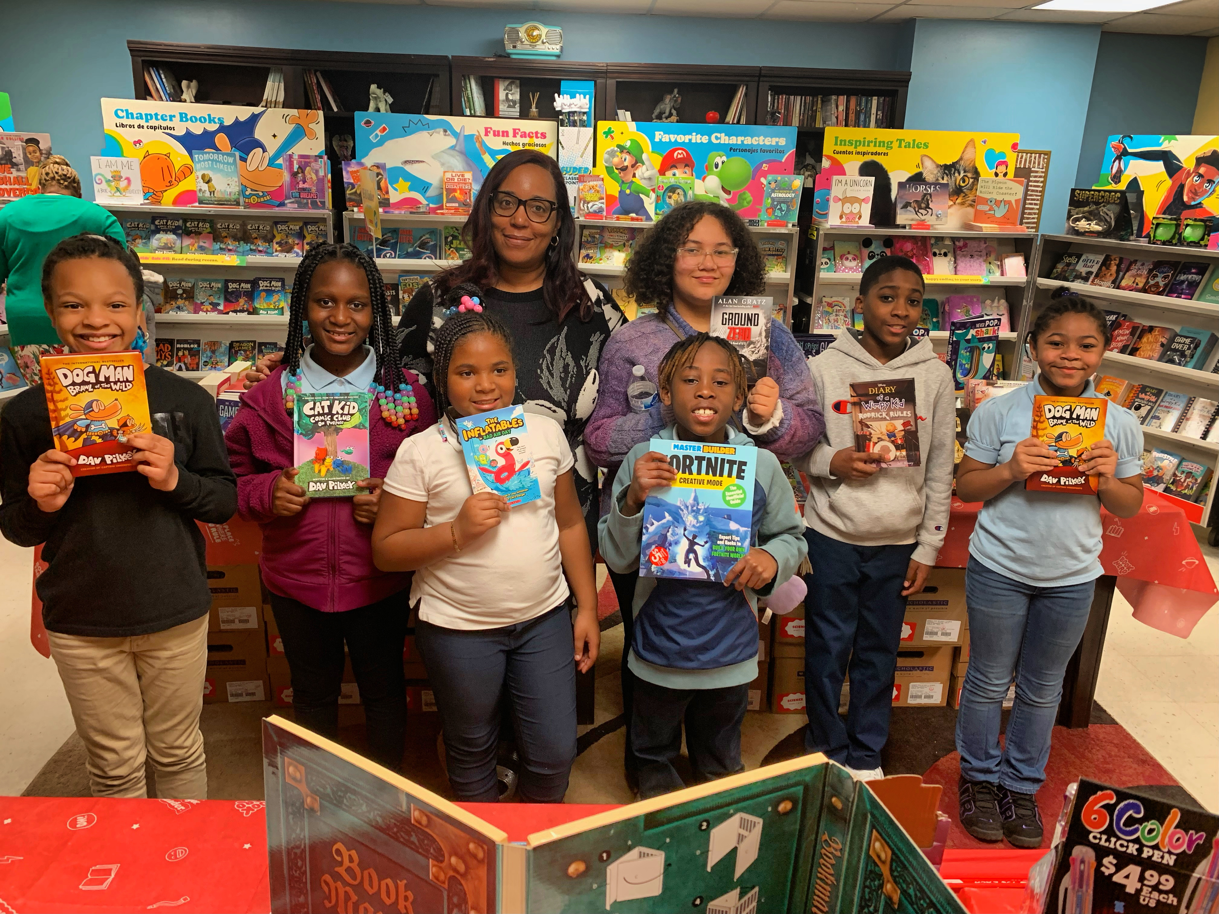 Seven DAAS Scholars, with Principal Manthiram, selecting their next favorite book from the DAAS Book Fair.
